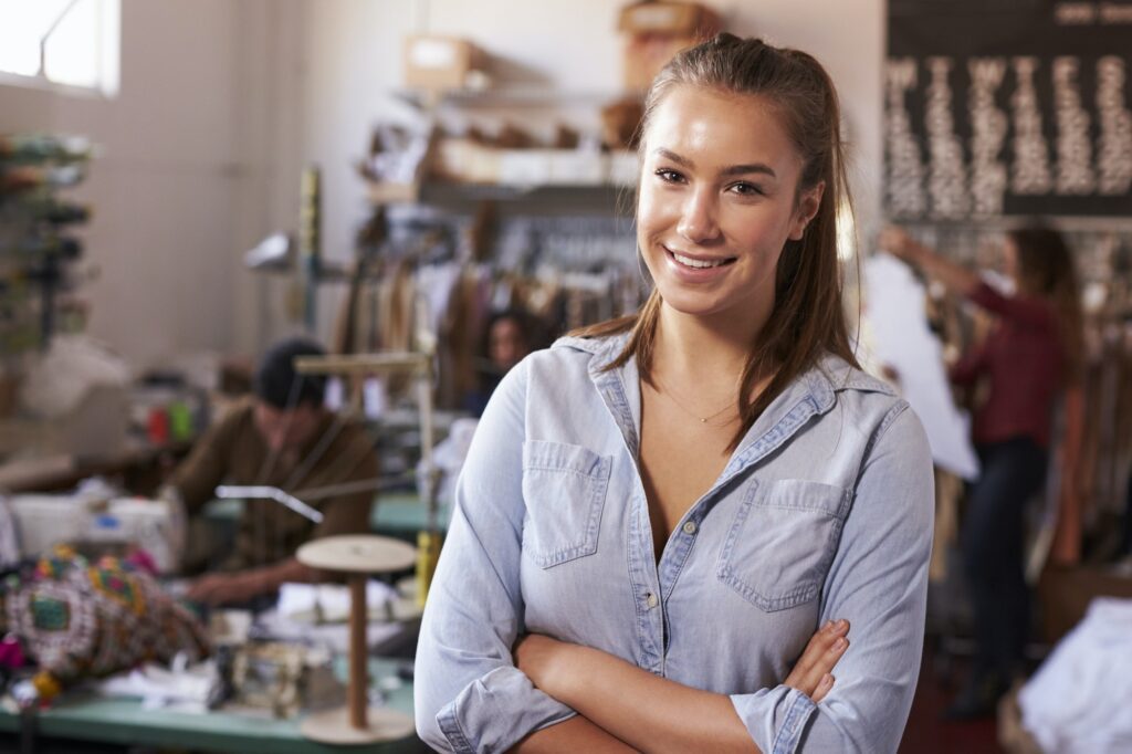 Smiling white female trainee in clothing design studio