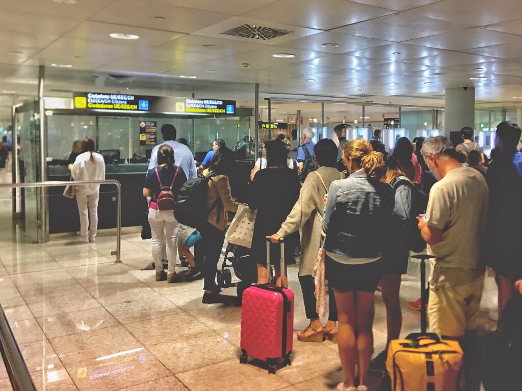 travelers stand in line at customs and immigration at the airport